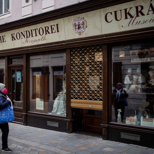 A woman stands in front of the closed patisserie in Bratislava downtown on November 25, 2021. - Slovakia declared a two-week lockdown following a spike in COVID-19 cases with the country�s seven-day average of cases rise above 10,000. (Photo by VLADIMIR SIMICEK/AFP)
