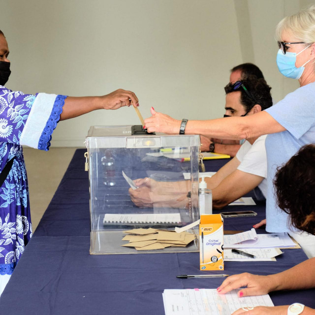 A woman casts her ballot for the referendum on independence at a polling station of the City Hall in Noumea, on the French South Pacific territory of New Caledonia on December 12, 2021. (Photo by Theo Rouby/AFP)
