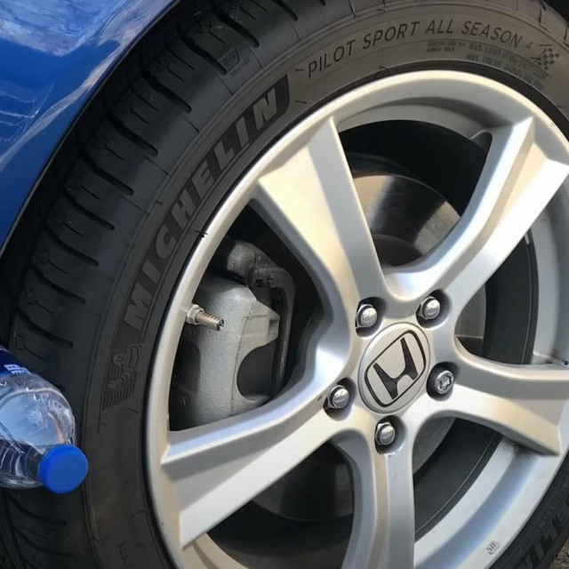 Plastična boca kod kotača na automobilu
