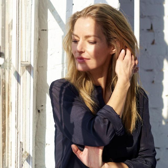 Close-up portrait shot of beautiful woman looking thoughtfully while standing by the window and relaxing.
