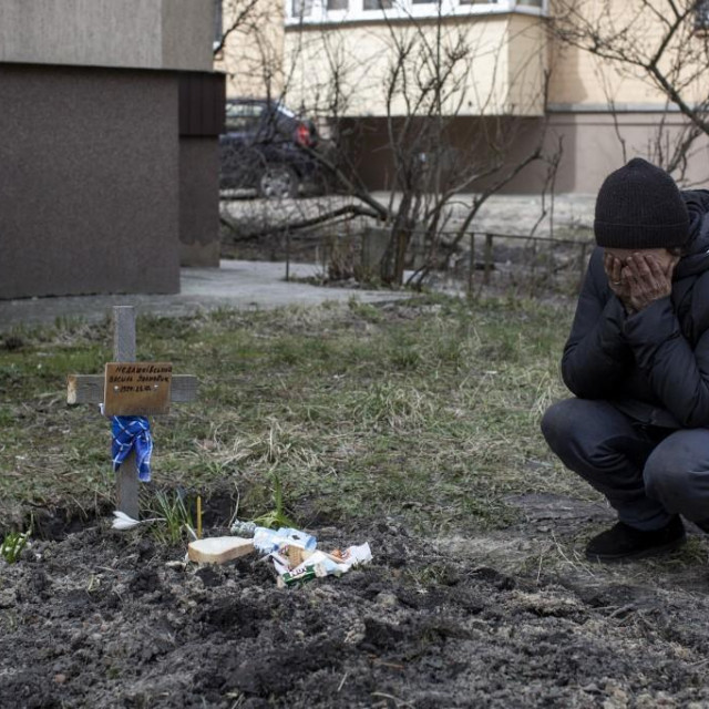 Žena iz Buče koja plače nad grobom svog muža