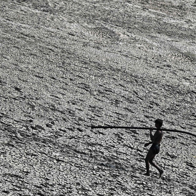 Muškarac nosi crijevo za vodu u New Delhiju