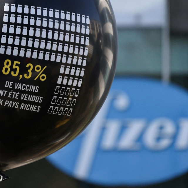 Amnesty International activists hold balloons during a protest to denounce the profit driven behaviour of pharmaceutical companies outside Pfizer's office in Brussels, on March 11, 2022. (Photo by Kenzo TRIBOUILLARD/AFP)