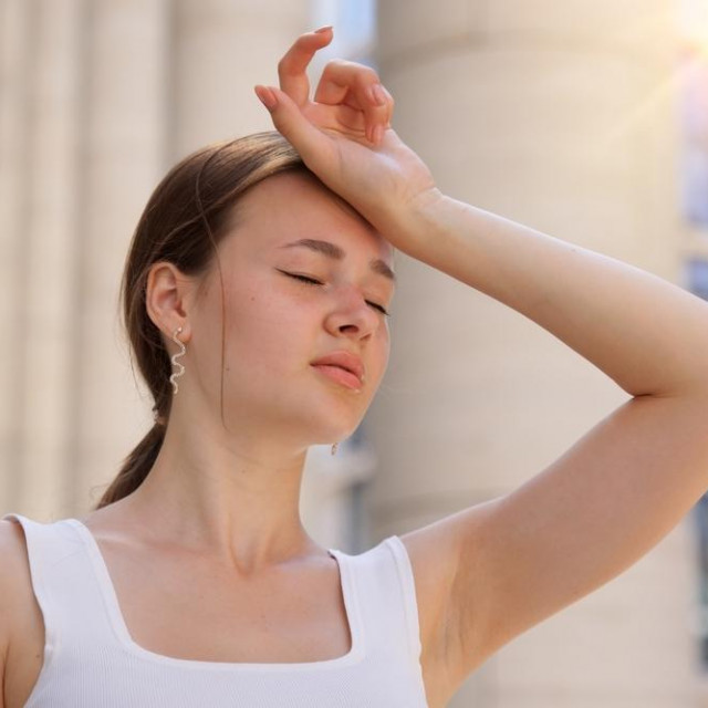 portrait of tired sick exhausted woman, beautiful girl is suffering from hot Summer heat stroke, sunshine, hot weather day, sweaty and thirsty, high temperature. Feeling unwell, unhealthy