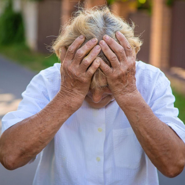 Starija gospođa drži se za glavu, ilustracija