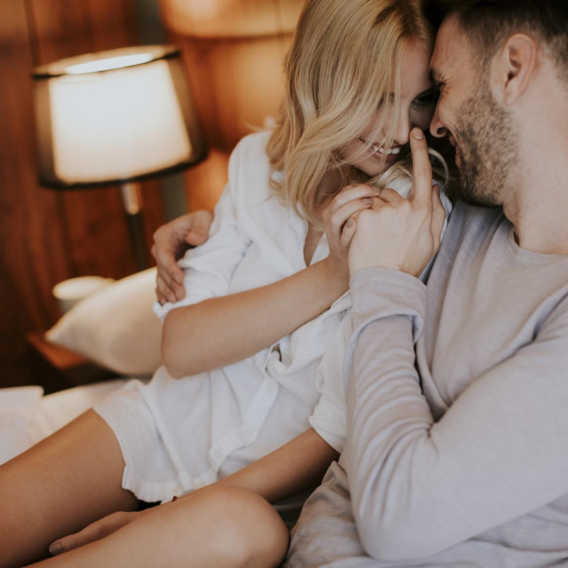 Loving couple on the bed in the bedroom