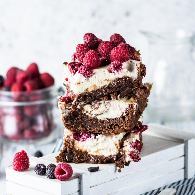 Cheesecake brownies with raspberry stacked on a plate. Melting chocolate. Piece of cake. Brownie dessert. Cherry and raspberry. Valentines day. Women‘s day. Spring dessert. Summer cake