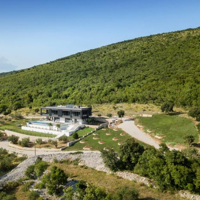 MJESTO NA KOJEM JE PODIGNUTA KUĆA SPAJA GOTOVO NESPOJIVO - PLAVETNILO S JEDNE STRANE I GUSTU ŠUMU S DRUGE