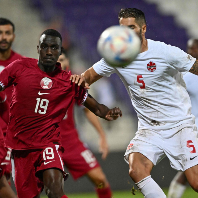 Qatar‘s forward Almoez Ali (L) and Canada‘s defender Steven Vitoria vie for the ball during the friendly football match between Qatar and Canada in Vienna on September 23, 2022. (Photo by JOE KLAMAR/AFP)