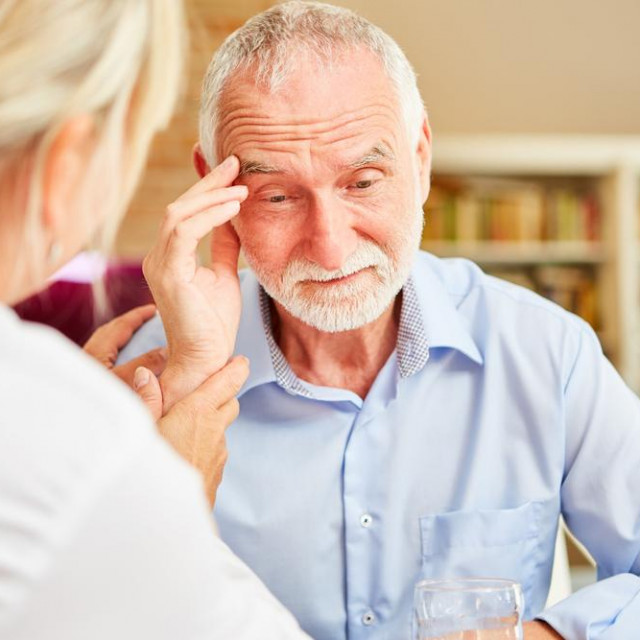 Senior with dementia or Alzheimer‘s is comforted by caring female doctor