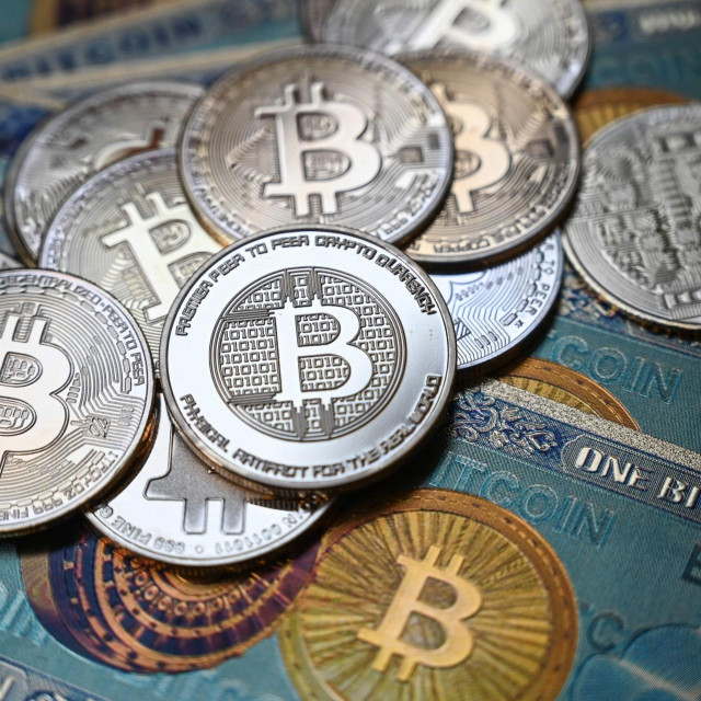 (FILES) In this file illustration photograph taken on July 19, 2021 in Istanbul shows a physical banknote and coin imitations of the Bitcoin crypto currency. - The US government announced November 7, 2022 it had seized $3.4 billion in bitcoin from a real estate developer who stole the cryptocurrency from the dark web marketplace Silk Road a decade ago. (Photo by Ozan KOSE/AFP)
