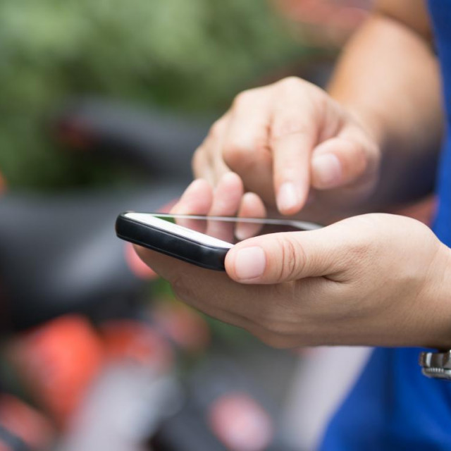 Hands using martphone in modern city