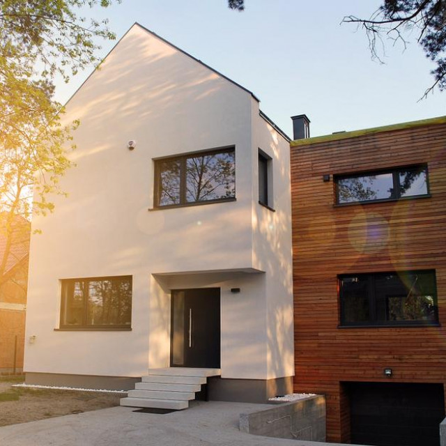 Luxury real estate single family house with wooden facade, view during sunset.