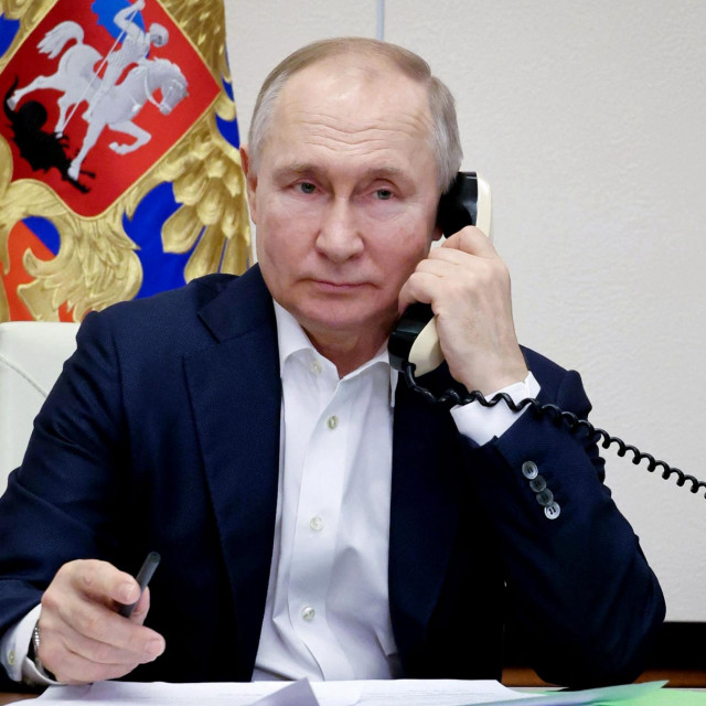 Russian President Vladimir Putin talks on the phone with Agatha Bylkova, a eight-year-old girl from the Kurgan region who took part in the New Year Tree of Wishes nationwide charity campaign, in Moscow on January 3, 2023. (Photo by Mikhail Klimentyev/SPUTNIK/AFP)