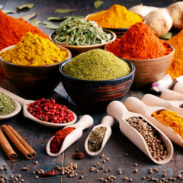 Variety of spices and herbs on kitchen table.