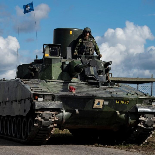 Švedsko oklopno voziklo na otoku Gotland i borbeni avion JAS 39 Gripen u pozadini