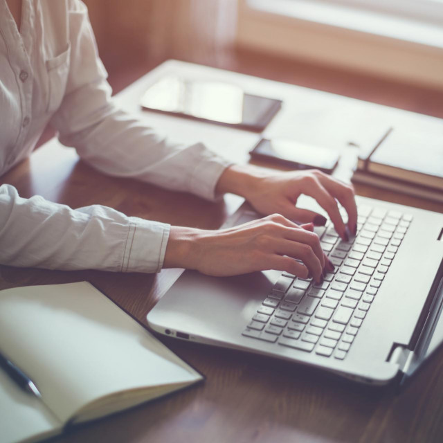 Businesswoman typing on laptop at workplace Woman working in home office hand keyboard