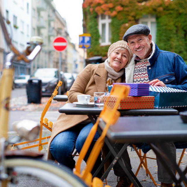 Senior people sitting in outdoor cafe in city, a coronavirus concept.