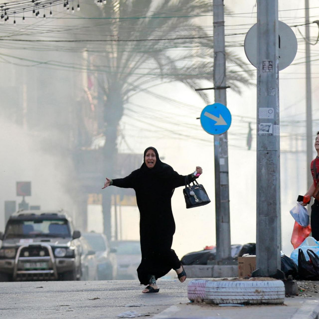 Palestinians run for cover after a strike near the Al-Shifa hopsital in Gaza City on November 1, 2023, amid the ongoing battles between Israel and the Palestinian group Hamas. (Photo by Bashar TALEB/AFP)