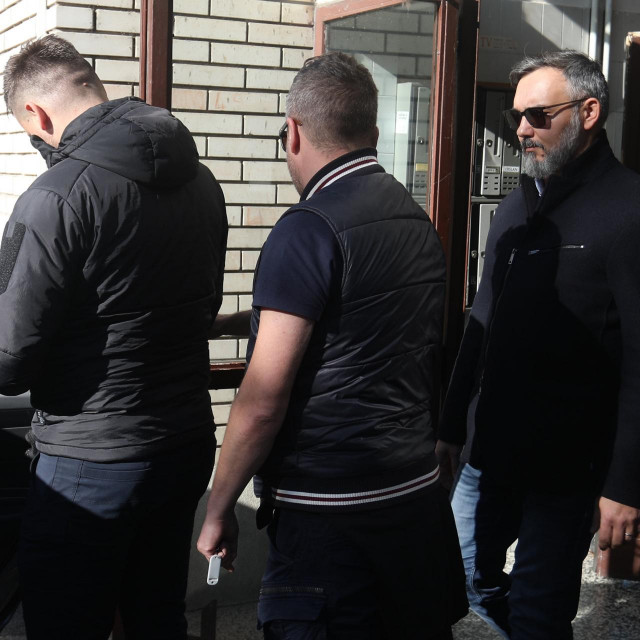 Almin Đapo izlazi iz zgrade u pratnji istražitelja