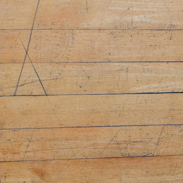 Old and scratch parquet floor at gymnasium.