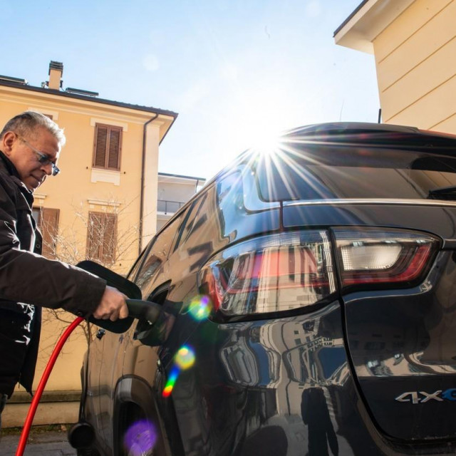 Čovjek puni svoj električni auto u L‘Aquili u Italiji
