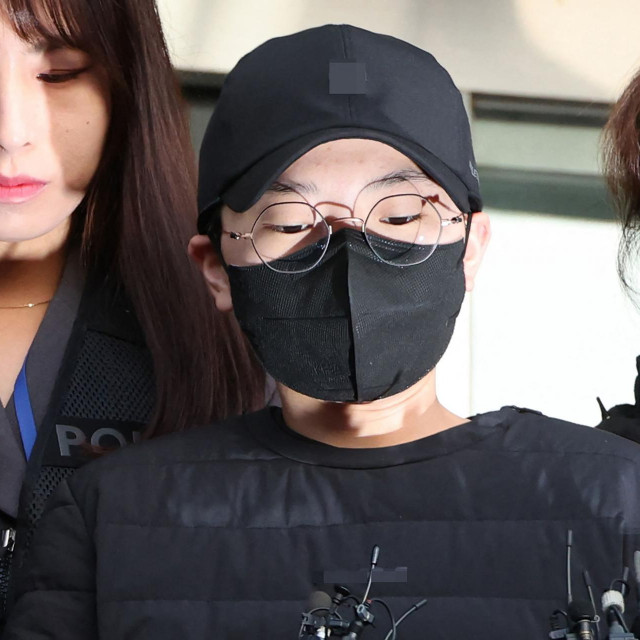 Jeon Cheong-jo (u sredini) s policijskom pratnjom