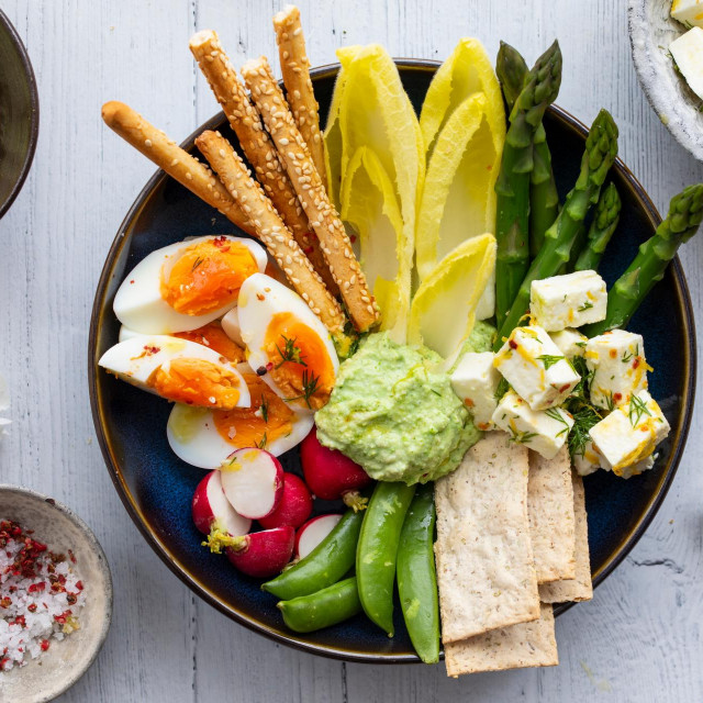 Easter sharing platter with eggs, asparagus, crunchy vegetables and feta