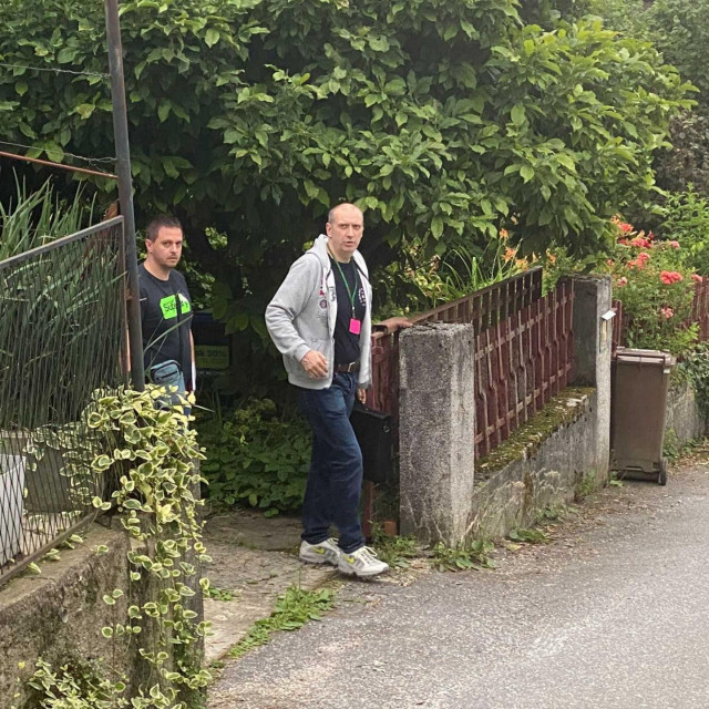 Policijski istražitelj u dvorištu kuće