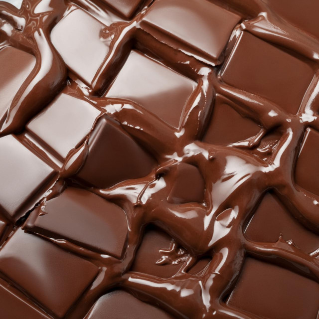 Melted pieces of dark chocolate bar in splash texture