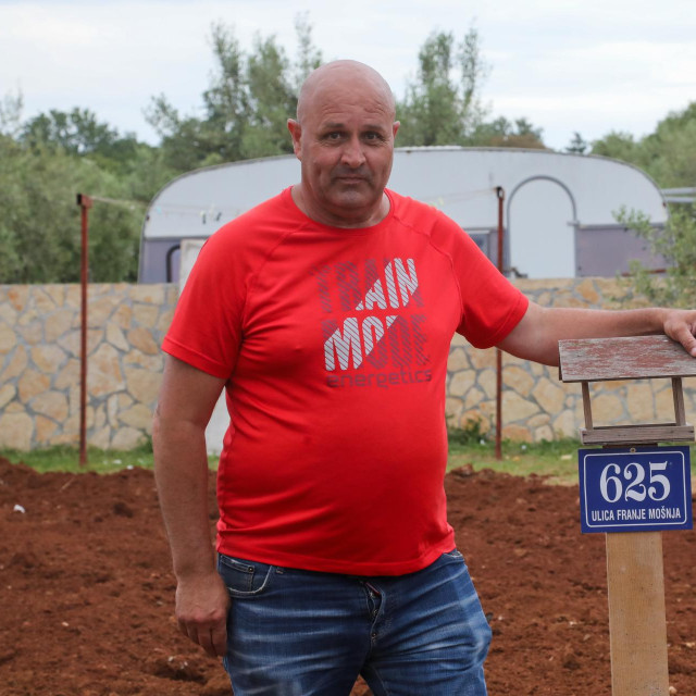 Jure Guberac na svojoj parceli uz tablu ulice i kućnog broja. Sam je srušio kuću.