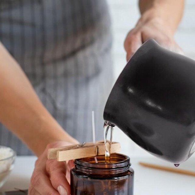 Žena ulijeva u čašu za svijeću rastopljeni sojin vosak: takve svijeće, kao i one od pčelinjeg voska, zdrava su varijanta i njih birajte - savjetuje ugledni gastroenteorolog