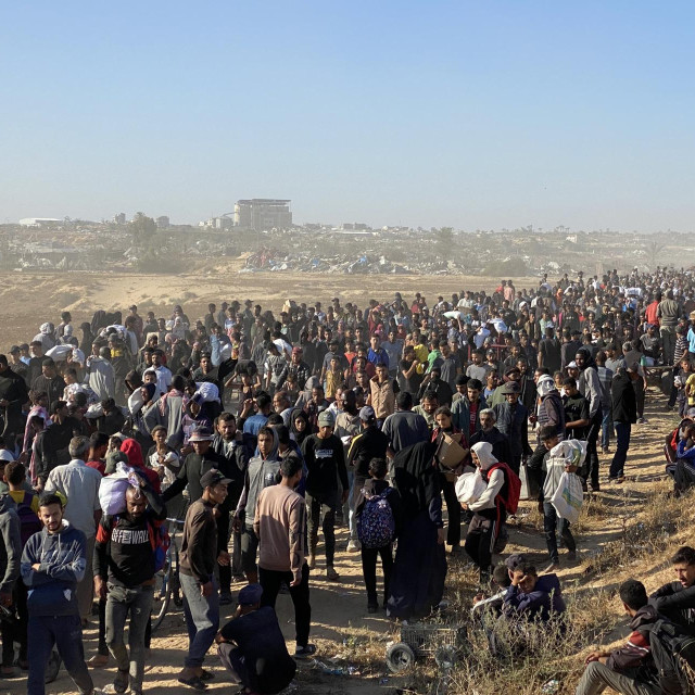 Raseljeni Palestinci nose vreće s humanitarnom pomoći u svoje šatore na jugu Pojasa Gaze