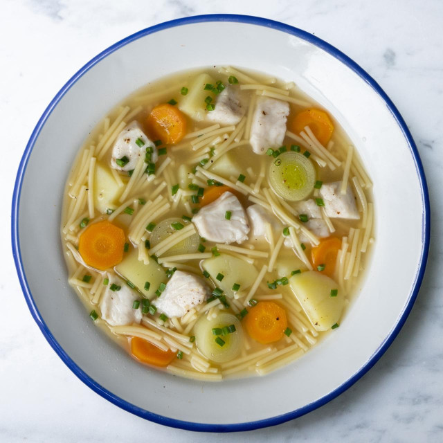 Fish, noodle and vegetable soup. Top view table with decoration..