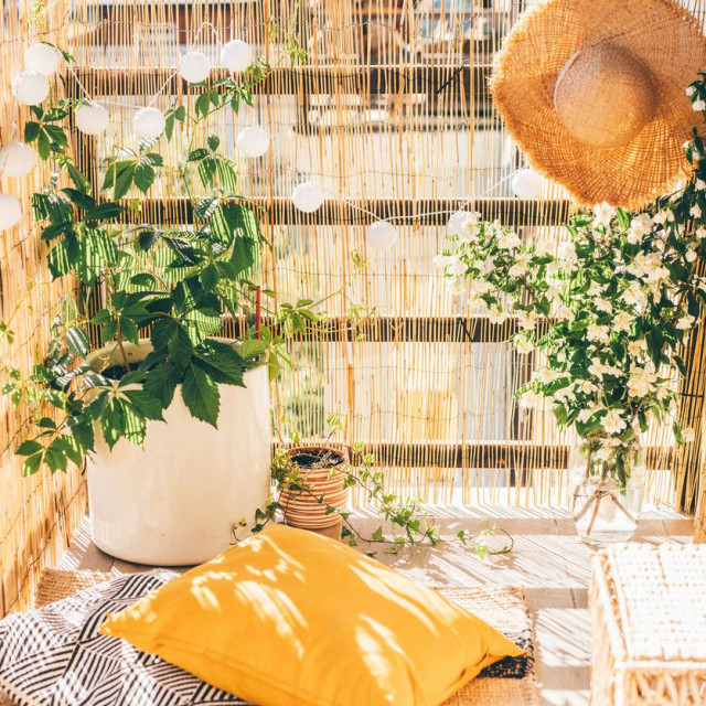 Eco friendly bamboo terrace. Orange pillows on the floor.