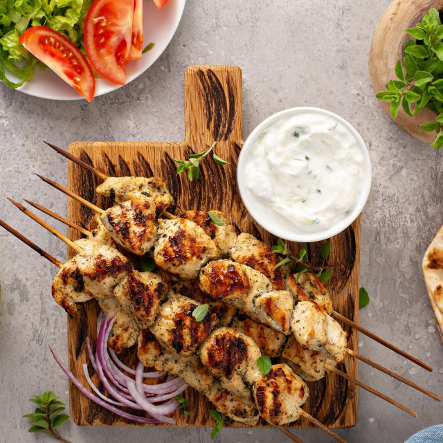 Greek chicken souvlaki with tzatziki sauce and fresh vegetables, grilled kebabs