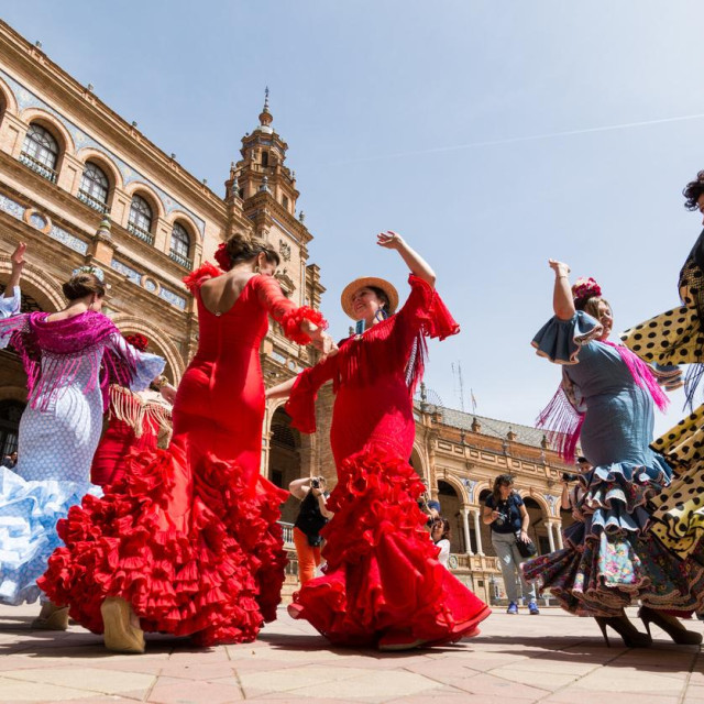 Seville, Spain - May 2017: Young women dance flamenco on Plaza de Espana during famous Feria festival