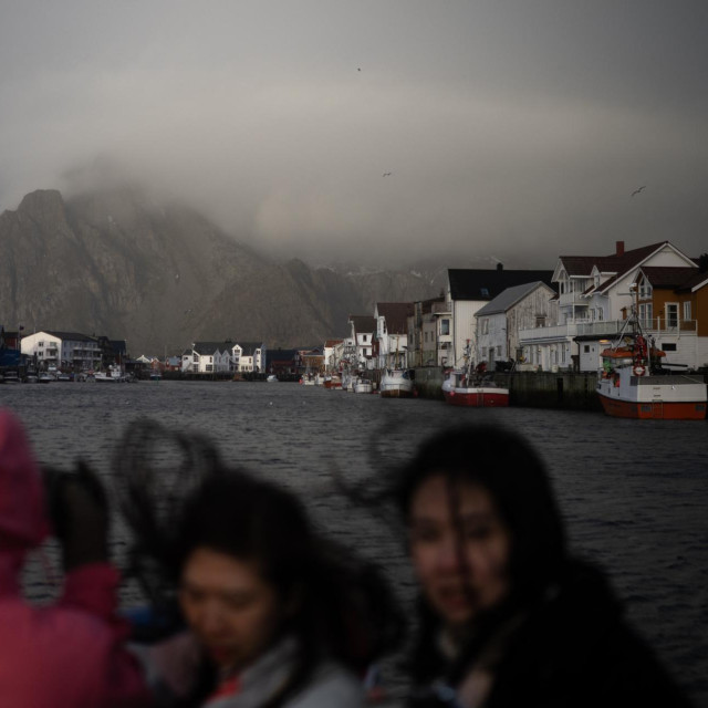 Turisti u luci u selu Henningsvær u Norveškoj