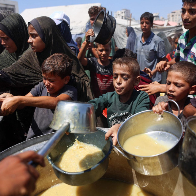 Palestinci primaju juhu od leće na punktu za distribuciju hrane u Gaza Cityju