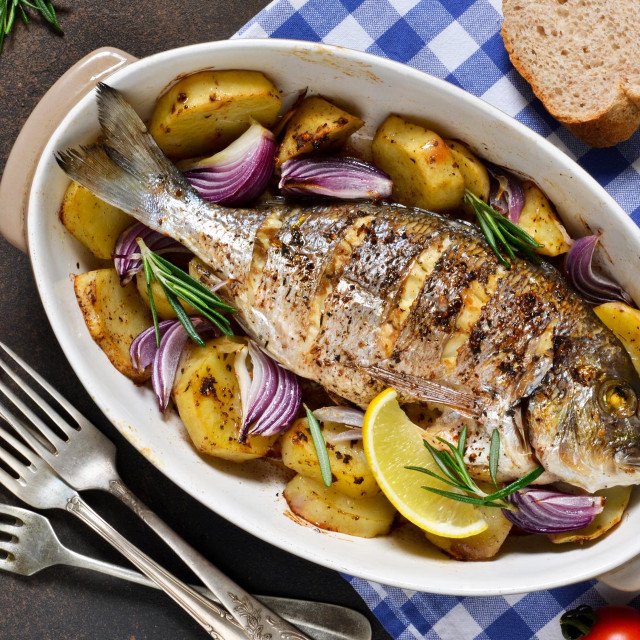 Baked dorado with Provencal herbs and potatoes.