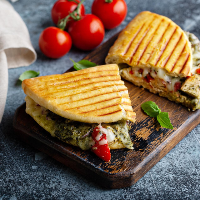 Chicken tomato pesto panini cut in half