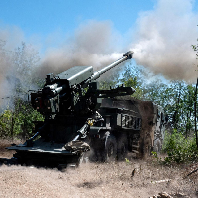 Pripadnik ukrajinske 44. samostalne topničke brigade stoji uz haubicu 2S22 Bohdana tijekom borbene zadaće