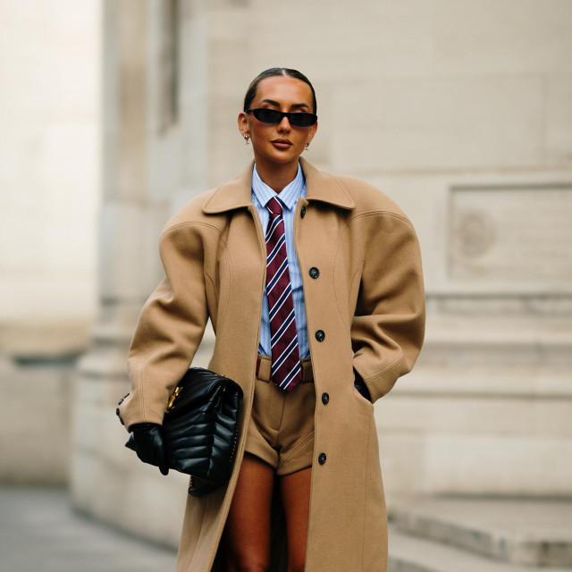 Klasičan kaput u boji devine dlake zanimljiv je zbog predimenzioniranih ramena