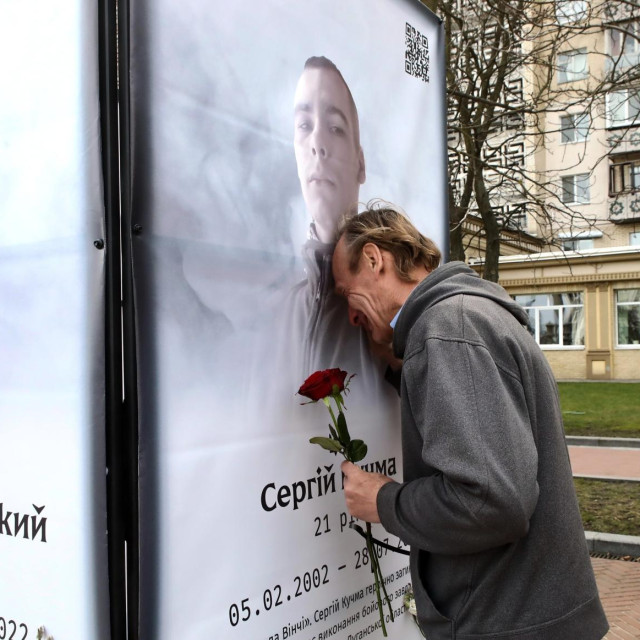 Ukrajinac oplakuje bližnjeg kod spomenika žrtvama u Kijevu, arhivska fotografija