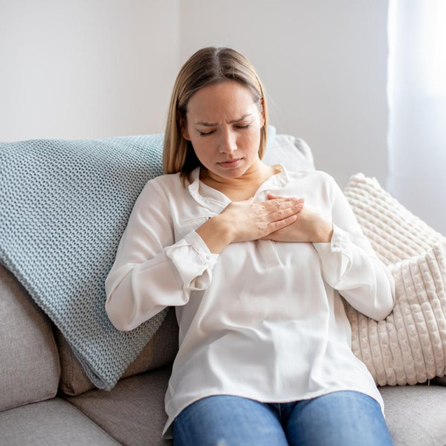 Woman having chest pain. respiratory system diseases. Girl having a heart attack at home.