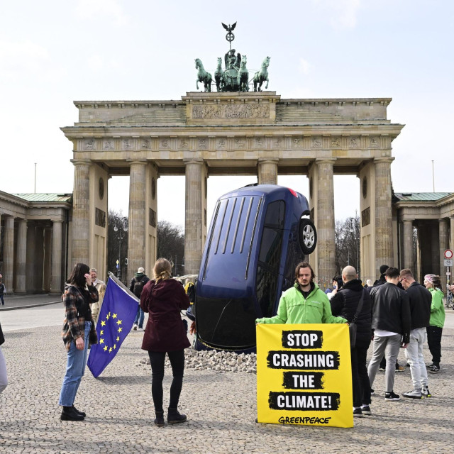 Arhivska fotografija: Instalacija aktivista Greenpeacea prikazuje SUV koji je naizgled zabijen u pločnik ispred Brandenburških vrata 22. ožujka 2023. u Berlinu u Njemačkoj. Greenpeace kritizira zahtjev njemačke vlade za izuzeće od novih propisa EU-a koji bi zabranili prodaju automobila s motorima s unutarnjim izgaranjem do 2030. godine.