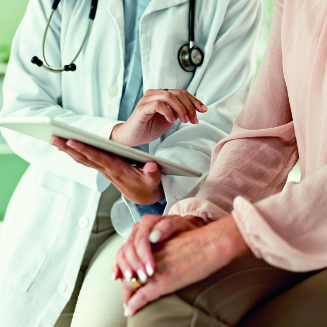 Clinic, tablet and hands of doctor with patient for consulting, medical service and help in hospital. Healthcare, telehealth and people on digital tech for diagnosis, online results and insurance