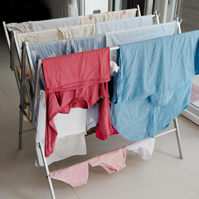 Clothes dryer with wet linen at home. Housekeeping concept