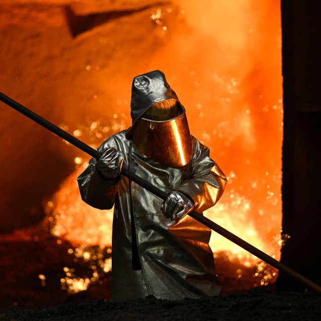Radnik uzima uzorak čelika iz visoke peći u pogonu njemačkog industrijskog giganta Thyssenkruppa, 20. ožujka 2025. u Duisburgu, na zapadu Njemačke