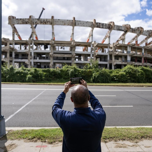 Muškarac snima fotografiju radova na rušenju stadiona Robert F. Kennedy Memorial. Na tom će mjestu biti izgrađen novi stadion tima Commanders, čije se otvaranje očekuje 2030. godine.